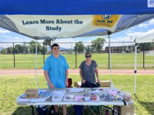 Dr. Erin Bell and her son standing at the PFAS Health Study Table