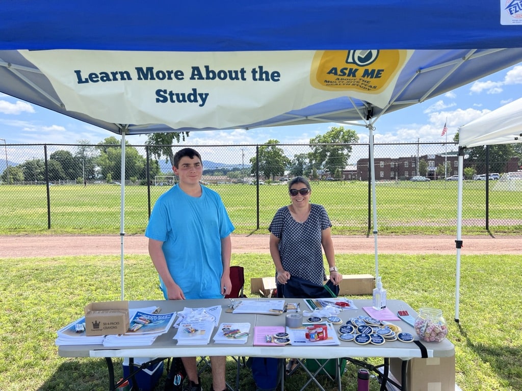 Dr. Erin Bell and her son standing at the PFAS Health Study Table 