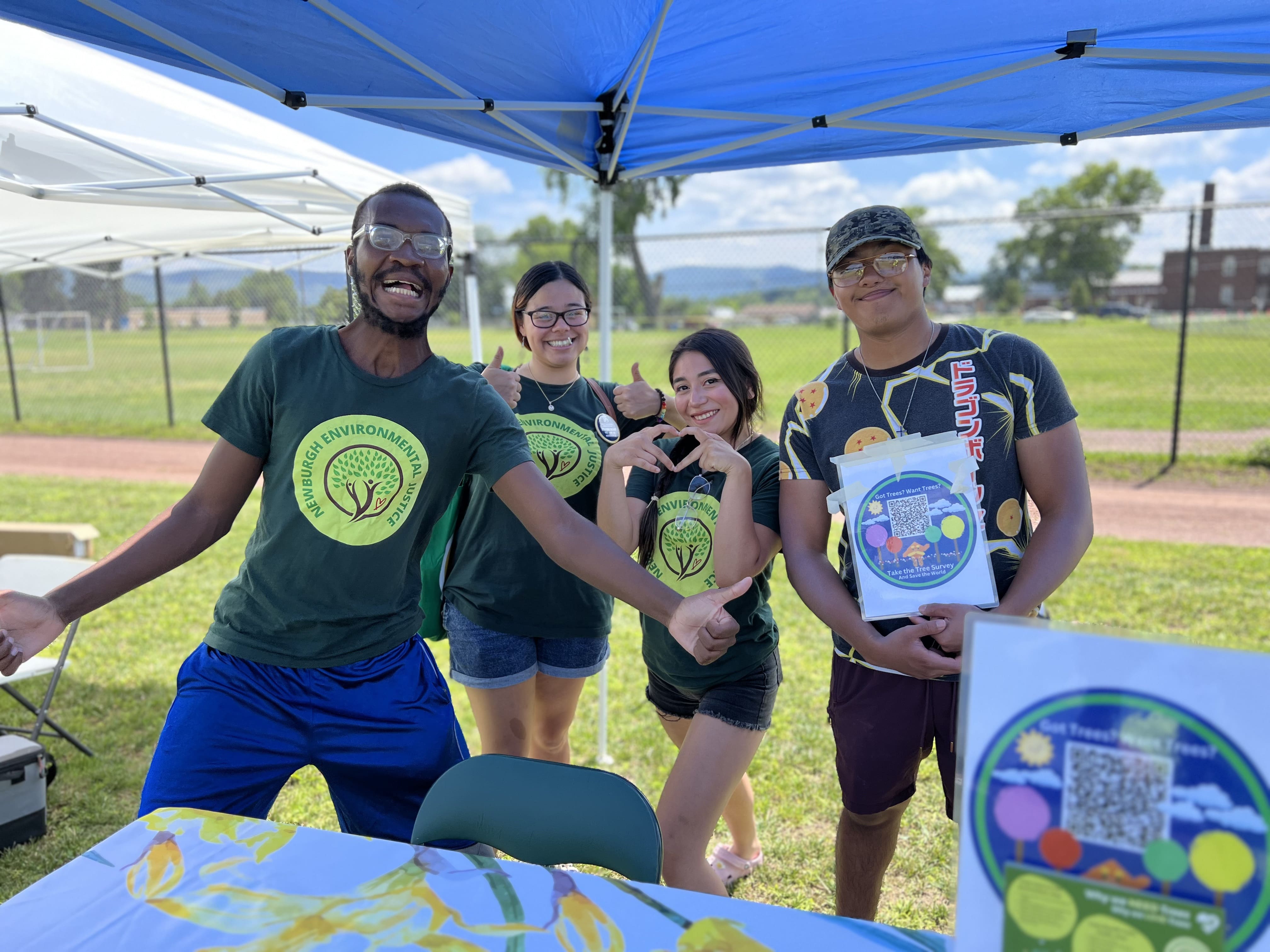 Quatre boursiers en justice environnementale debout derrière leur table au Love Our City Fest