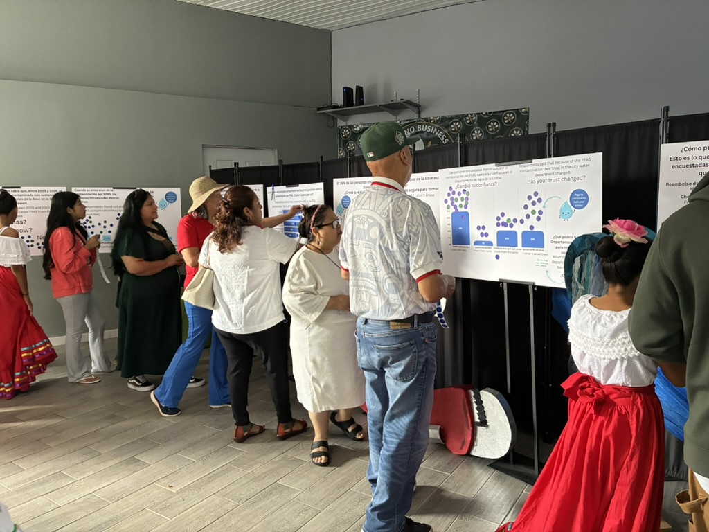 Newburgh residents reading the bilingual research poster boards and placing dot stickers at Clean Water Community Day